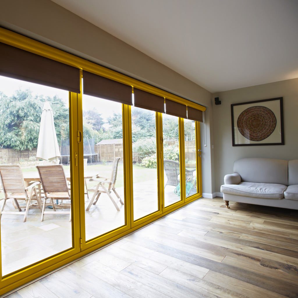 powder coated aluminium windows and yellow origin bifolds in a lounge