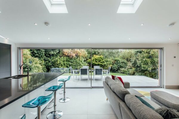 ultra slim minimalist sliding doors in a kitchen dining extension with garden views
