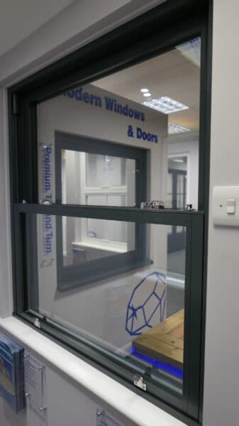 aluminium sliding sash windows in grey in a showroom