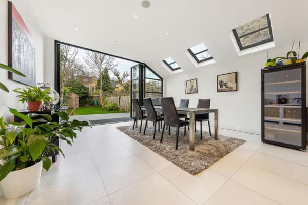 open plan dining room with open bifold doors and rooflights