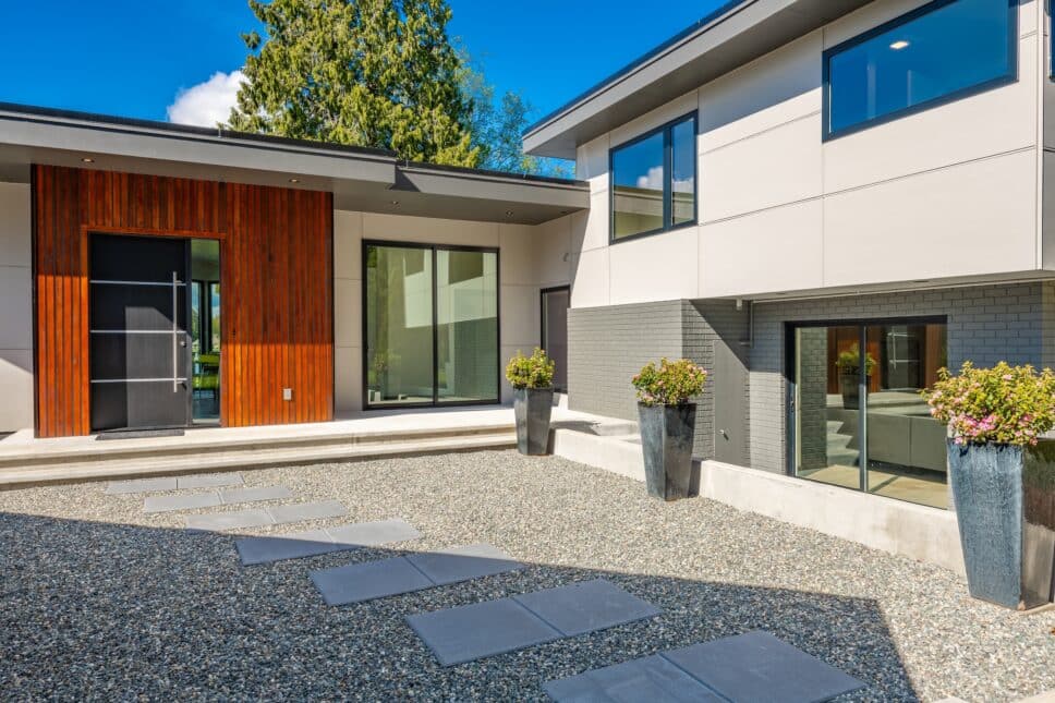 windows and doors for self-build homes showing contemporary home exterior on lakeshore with flat roof and large feature windows