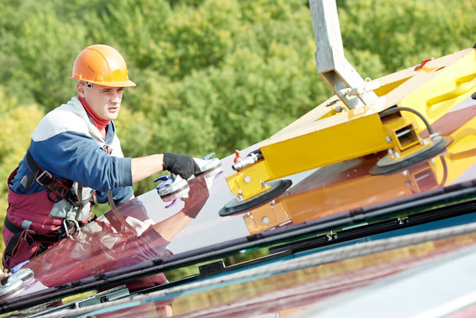 double glazing installer moving glass windows on facade of business building