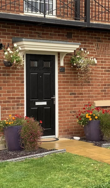 black rockroor front door with period canopy in new build house