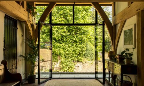 steel look french doors in the art-deco style fully open leading to a path