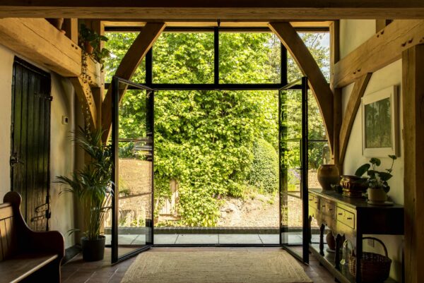 steel look french doors in the art-deco style fully open leading to a path