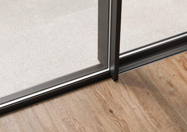 schüco ase 51 pd close up of door centre interlock on wood floor with flush track.