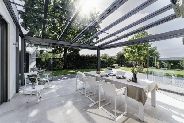 solarlux canopy and glass room set for dinner on a summer evening