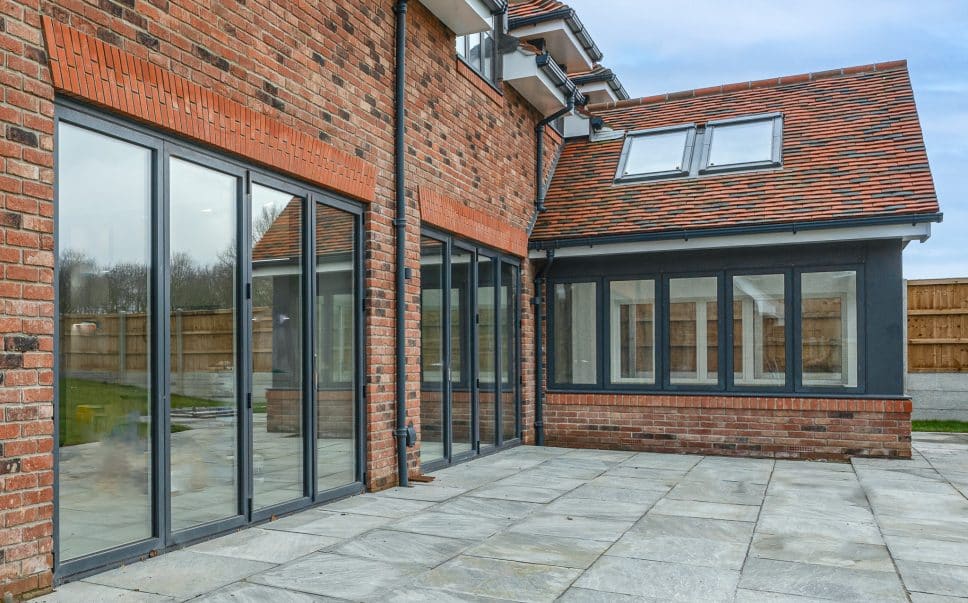 alumil bifolding doors in a detached house next to a conservatory extension