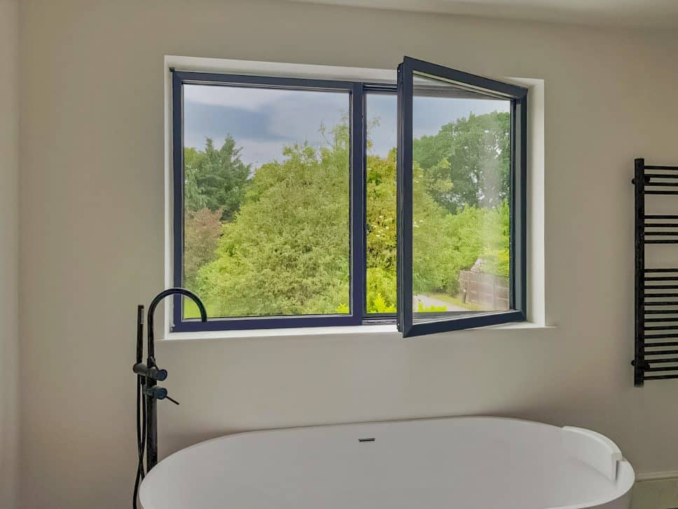 alumil windows showing the s77 tilt and turn window in a bathroom setting