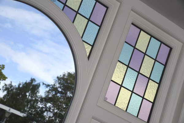 close up of timber window with intricate curve and stained glass