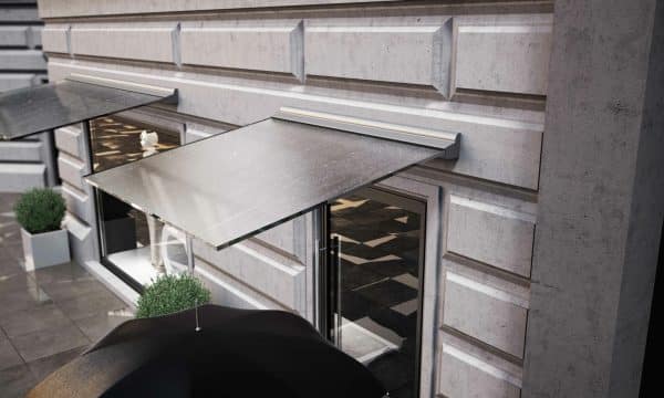 aluminium and glass canopies over shops in a stone clad building