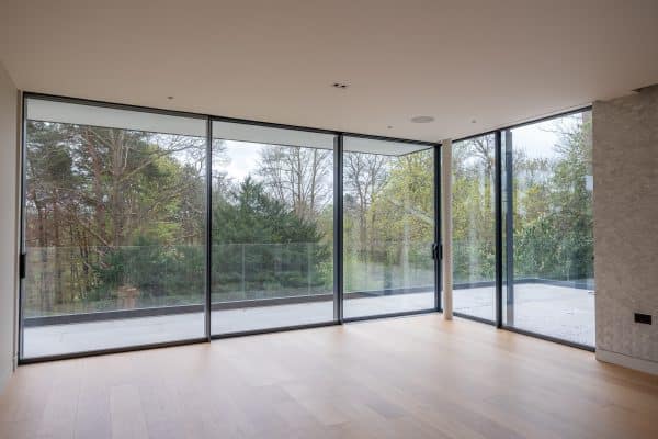 bare room with corner set of sliding doors made by skyglaze
