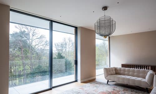 slimline sliding doors and picture window with glass balustrade and forest views