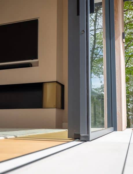 outside view of living room sliding doors, fully open with a tiled track and wood floor inside