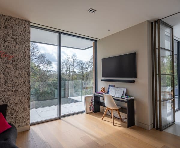 unequal lset of sliding doors in childrens room with piano and television