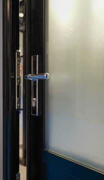 picture of partially open steel look front door with handle and lock