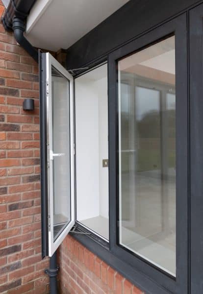 partially open grey and white flush casement window