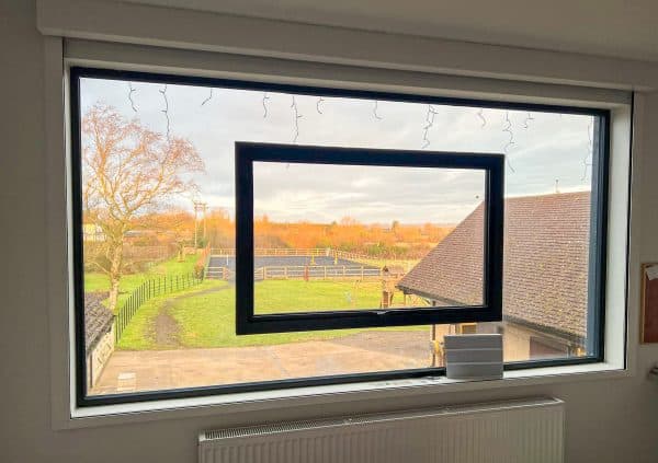frameless window in a bedroom showring opening sash fitted in glass